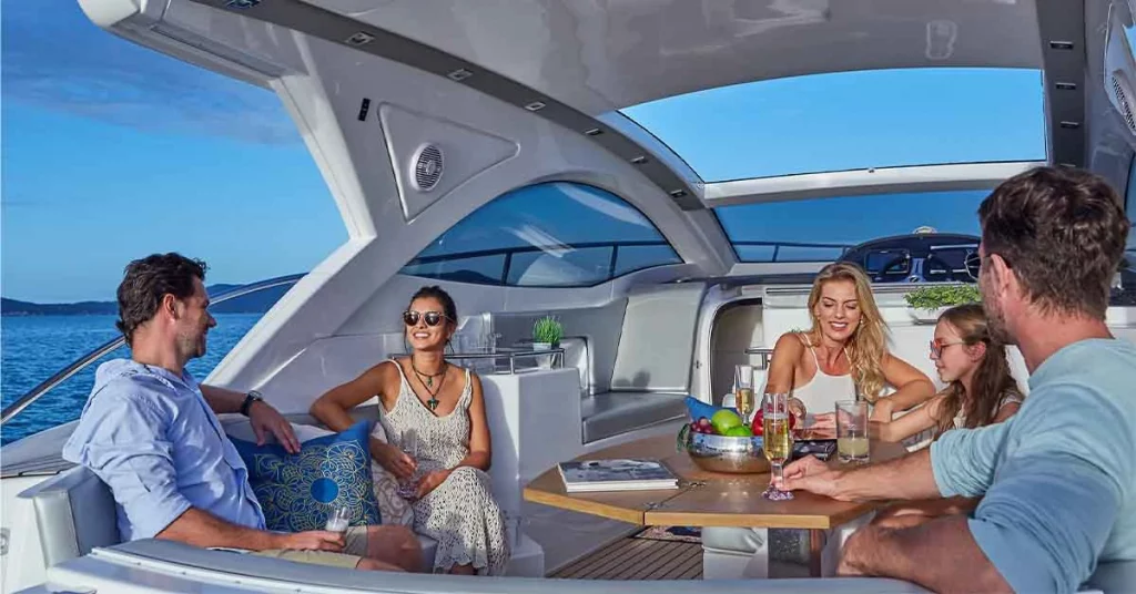 Group of boaters relaxing and having a conversation on the boat, enjoying the company and scenic surroundings.